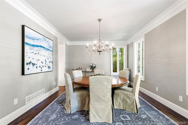 dining area with baseboards, wood finished floors, visible vents, and ornamental molding