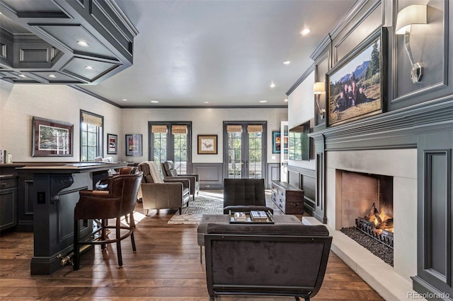 living area with dark wood-style floors, a wainscoted wall, french doors, and a high end fireplace