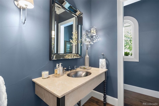 bathroom featuring vanity, wood finished floors, and baseboards