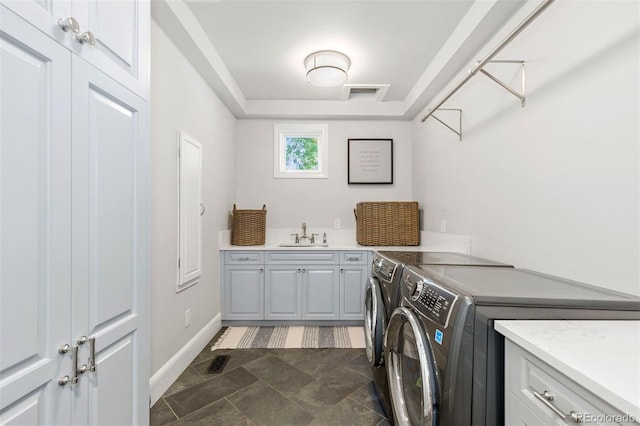 laundry area featuring visible vents, cabinet space, a sink, and separate washer and dryer