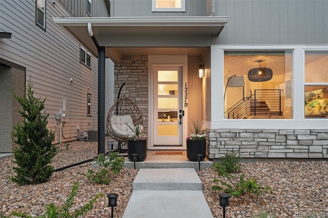 12270 W 57th Ave, Arvada, CO 80002 - property entrance featuring a porch, central AC unit, and stone siding