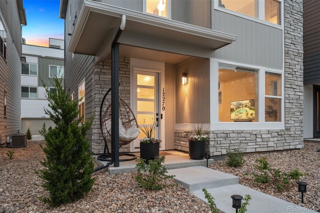 12270 W 57th Ave, Arvada, CO 80002 - property entrance with stone siding, a porch, and central AC unit