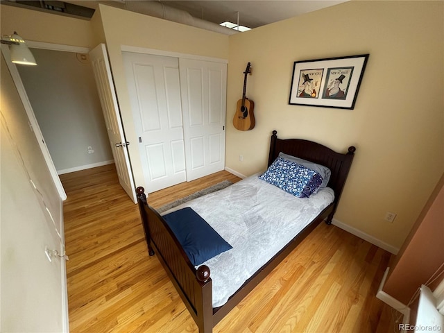 bedroom with light hardwood / wood-style flooring and a closet