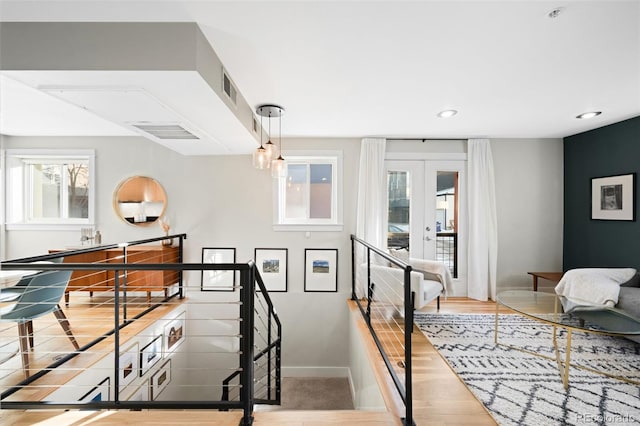 stairs featuring hardwood / wood-style floors and french doors