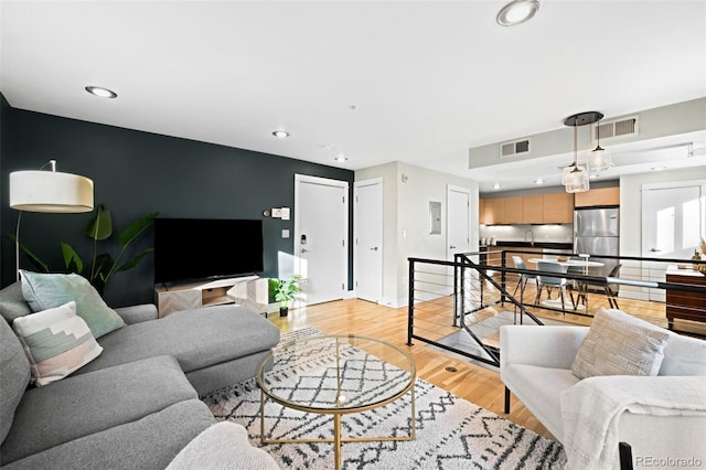 living room featuring recessed lighting, visible vents, and light wood-type flooring