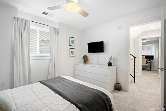 bedroom with a ceiling fan, visible vents, and light carpet