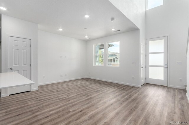 empty room featuring light wood-style floors, baseboards, and recessed lighting