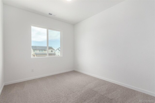 carpeted empty room featuring baseboards