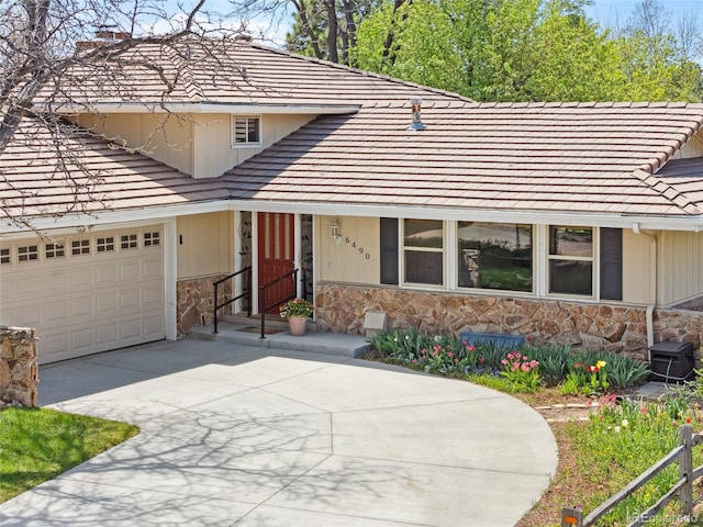6490 S Pontiac Ct, Centennial, CO 80111 - traditional home featuring a chimney, a tile roof, driveway, and stone siding