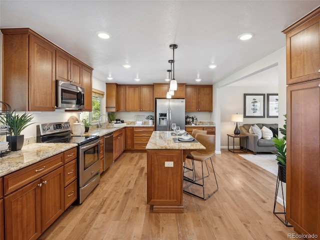 6490 S Pontiac Ct, Centennial, CO 80111 - kitchen featuring brown cabinetry, a kitchen island, a kitchen breakfast bar, a sink, and appliances with stainless steel finishes