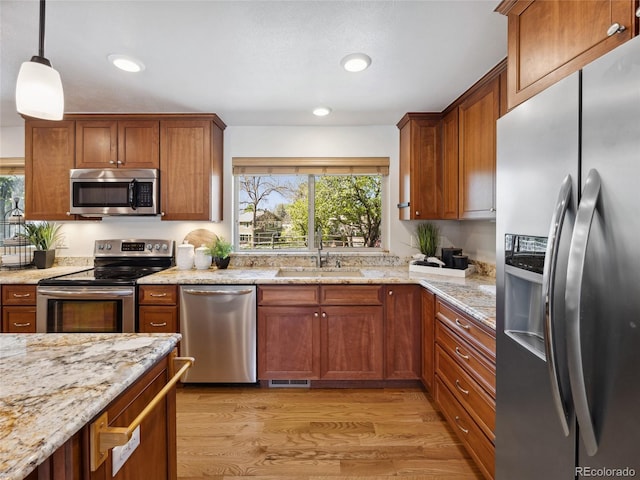 6490 S Pontiac Ct, Centennial, CO 80111 - kitchen featuring brown cabinets, light stone countertops, appliances with stainless steel finishes, and a sink