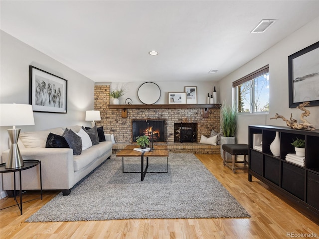 6490 S Pontiac Ct, Centennial, CO 80111 - living area featuring visible vents, a brick fireplace, and wood finished floors