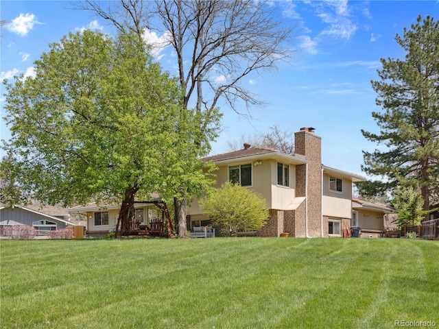 6490 S Pontiac Ct, Centennial, CO 80111 - rear view of property with a lawn, brick siding, and a chimney