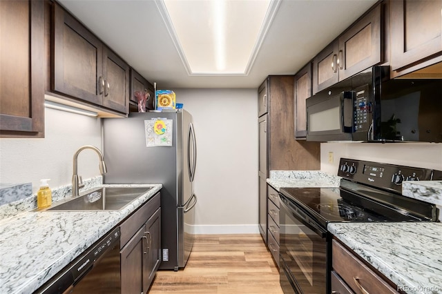 kitchen with sink, black appliances, dark brown cabinetry, and light wood-type flooring