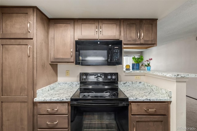 kitchen featuring black appliances and light stone countertops