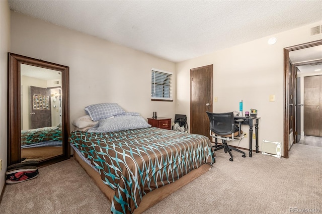 carpeted bedroom with a textured ceiling