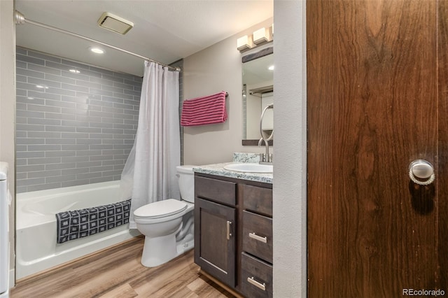 full bathroom featuring toilet, hardwood / wood-style floors, shower / bath combo, and vanity