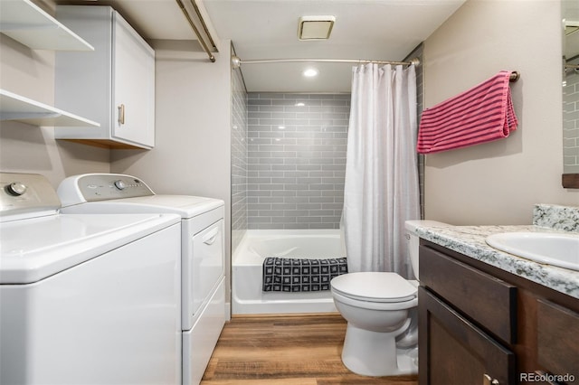 interior space featuring sink, washing machine and dryer, and wood-type flooring