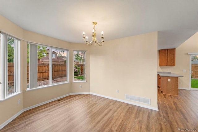 3371 Bexley Dr, Colorado Springs, CO 80922 - unfurnished dining area with light wood-style flooring, a chandelier, plenty of natural light, and baseboards