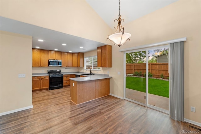 3371 Bexley Dr, Colorado Springs, CO 80922 - kitchen featuring black range with gas stovetop, stainless steel microwave, a sink, wood finished floors, and baseboards