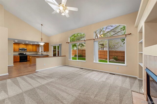 3371 Bexley Dr, Colorado Springs, CO 80922 - unfurnished living room with light colored carpet, healthy amount of natural light, high vaulted ceiling, a sink, and baseboards
