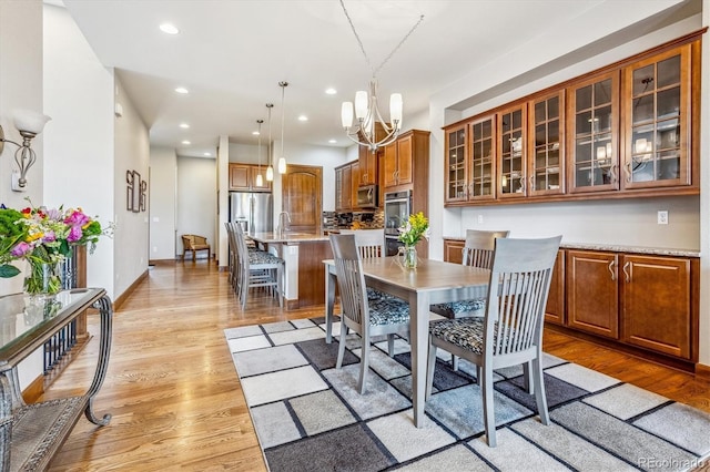 dining area featuring light hardwood / wood-style flooring and a chandelier