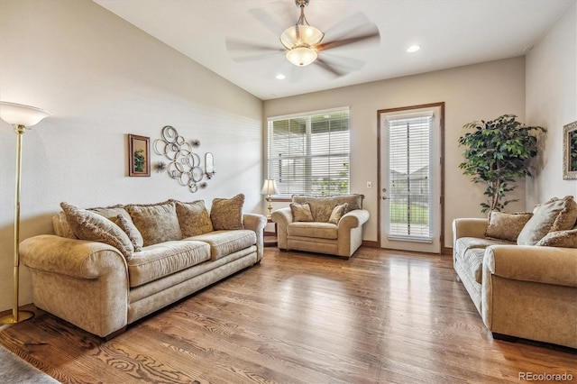 living room featuring hardwood / wood-style flooring, lofted ceiling, and ceiling fan