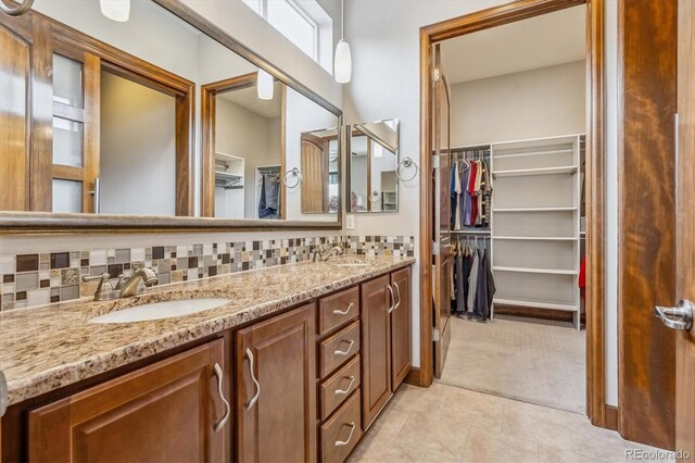 bathroom featuring dual vanity, backsplash, and tile patterned flooring