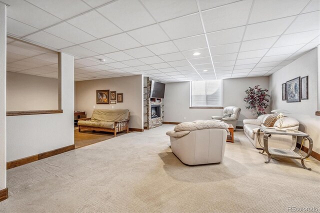 living room with a fireplace, a drop ceiling, and light colored carpet