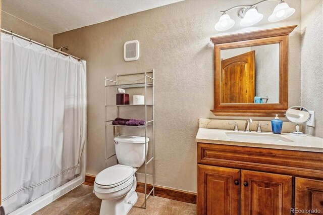 bathroom featuring tile patterned flooring, toilet, and vanity