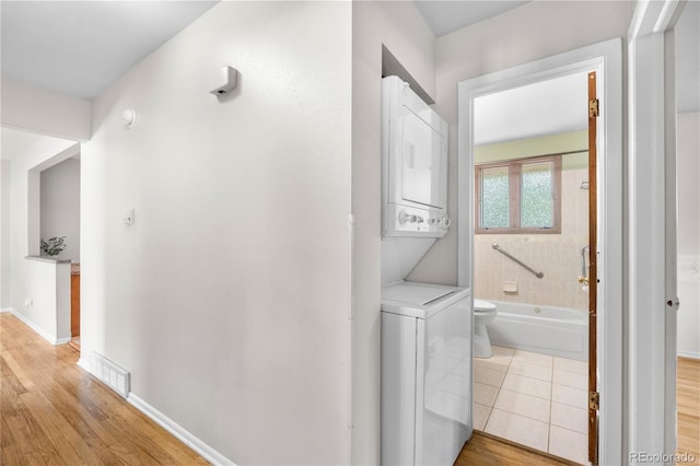 7742 W Florida Dr, Lakewood, CO 80232 - hallway featuring stacked washer and clothes dryer and light wood-style floors