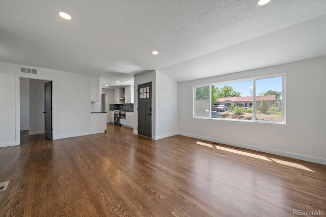 unfurnished living room featuring baseboards, recessed lighting, dark wood-style floors, and a textured ceiling