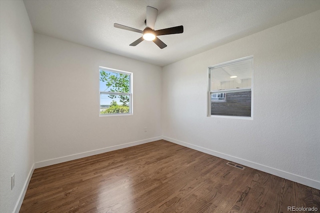 spare room featuring wood finished floors, a ceiling fan, and baseboards