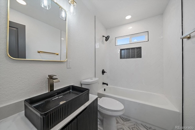 bathroom with toilet, tub / shower combination, a textured wall, and vanity