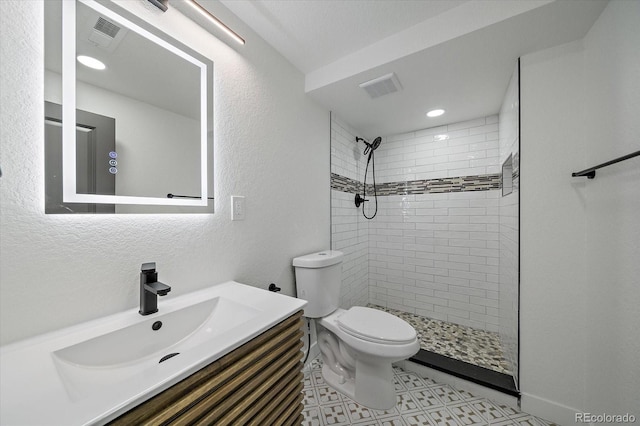 full bath with toilet, a tile shower, vanity, and recessed lighting