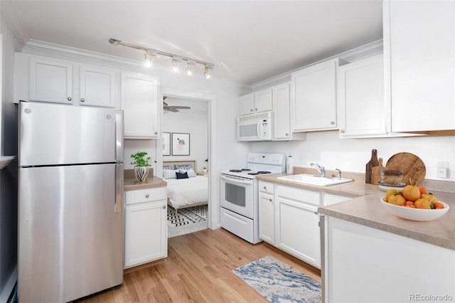 kitchen featuring sink, white cabinets, light hardwood / wood-style floors, and white appliances