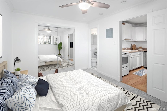 bedroom with ornamental molding, ceiling fan, sink, connected bathroom, and a closet