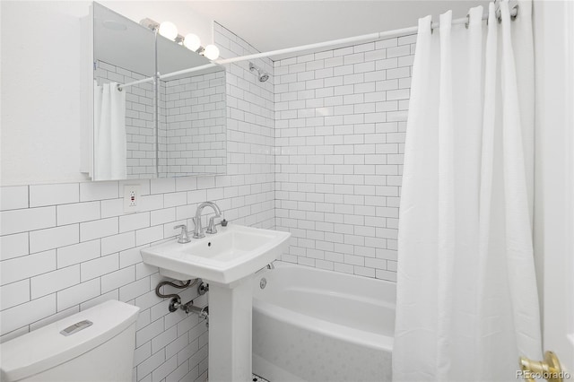 bathroom with toilet, tile walls, and shower / tub combo with curtain