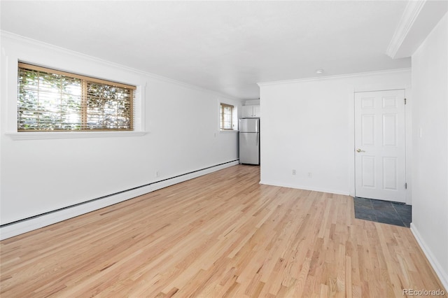 unfurnished room with light hardwood / wood-style floors, a baseboard radiator, a wealth of natural light, and crown molding