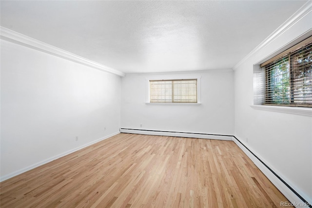 unfurnished room featuring crown molding, light wood-type flooring, and baseboard heating