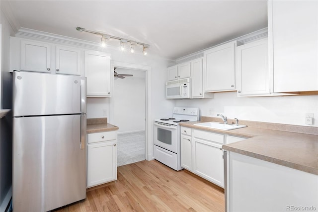 kitchen with white appliances, light hardwood / wood-style flooring, white cabinetry, and sink