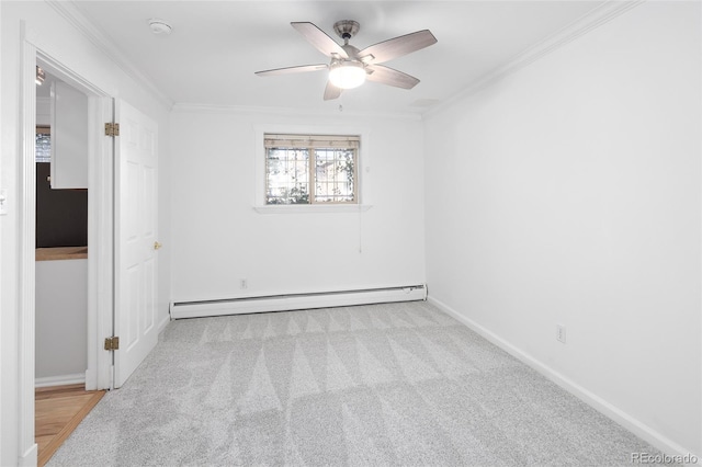 carpeted spare room with crown molding, ceiling fan, and a baseboard heating unit