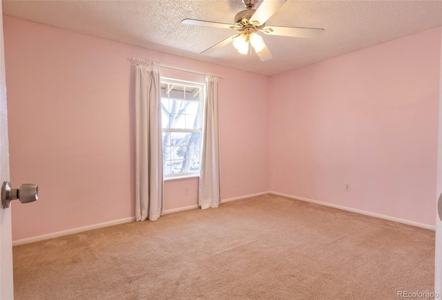 empty room with baseboards, carpet flooring, a textured ceiling, and ceiling fan