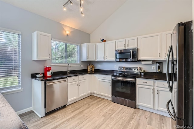 3734 Licorice Trl, Castle Rock, CO 80109 - kitchen with stainless steel appliances, white cabinetry, light wood-style flooring, high vaulted ceiling, and dark countertops