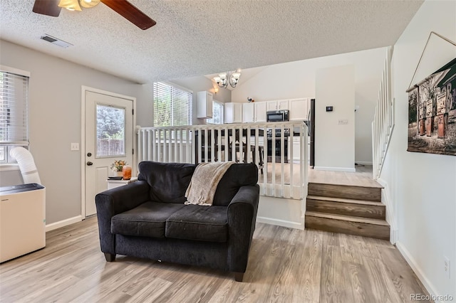 3734 Licorice Trl, Castle Rock, CO 80109 - living room featuring stairs, light wood-type flooring, a textured ceiling, a chandelier, and ceiling fan