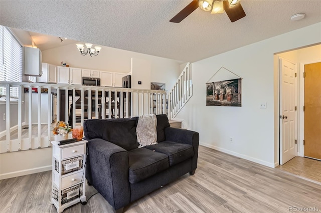 3734 Licorice Trl, Castle Rock, CO 80109 - living area with a ceiling fan, stairs, light wood finished floors, a textured ceiling, and a chandelier