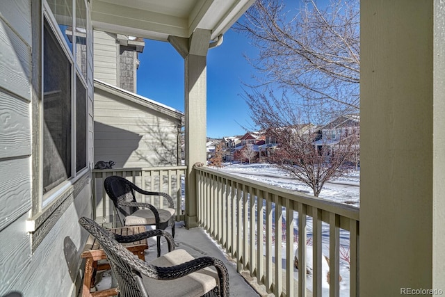 view of snow covered back of property