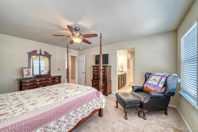 carpeted bedroom with a textured ceiling, ensuite bathroom, and ceiling fan