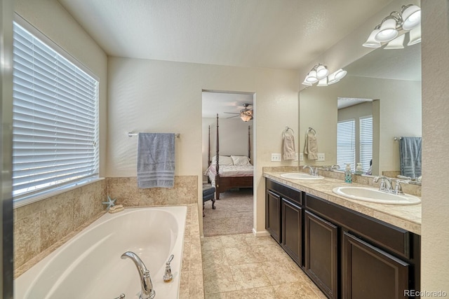 bathroom with a bath, vanity, and ceiling fan