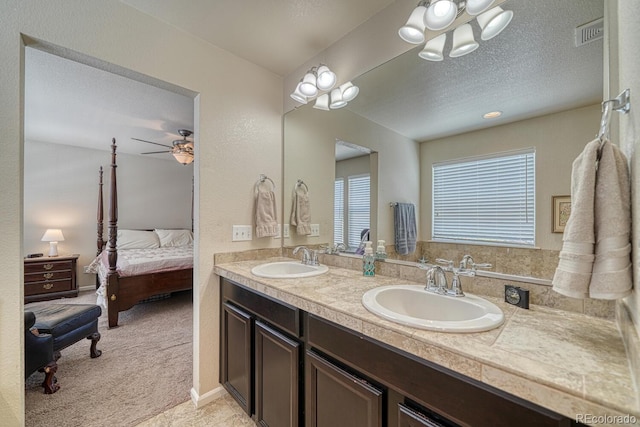 bathroom with vanity, ceiling fan, and a textured ceiling